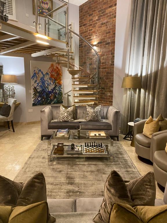a living room with a couch and a staircase at Executive Corporate Penthouse in Woking
