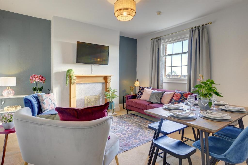 een woonkamer met een tafel en een bank bij Regency Nest by Spa Town Property - Stylish 3 Bedroom Apartment on 2 Floors, Central Leamington Spa in Leamington Spa