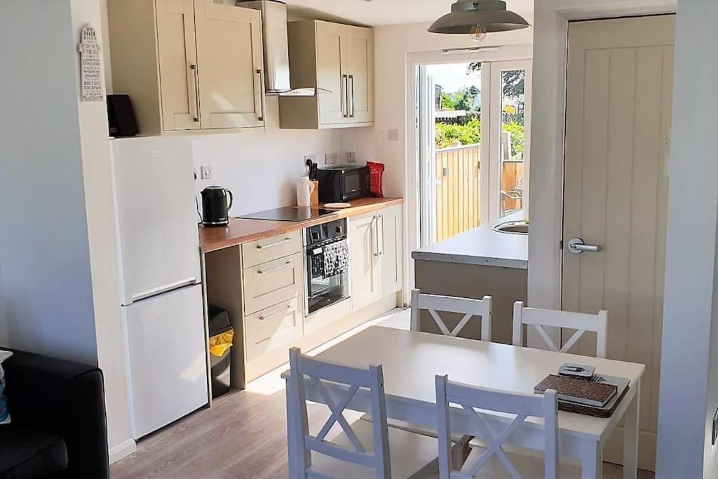 a kitchen with a table and chairs and a kitchen with a refrigerator at Woolacombe Breaks - ‘Sea La Vie’ in Woolacombe