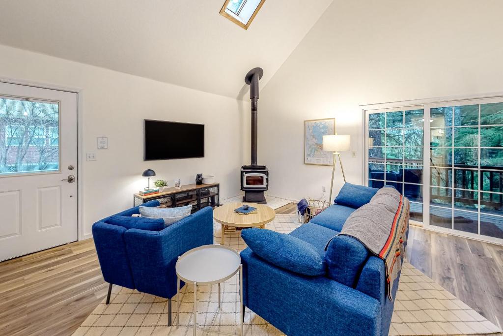 a living room with two blue couches and a fireplace at Treehouse by the Sea in Cape Meares