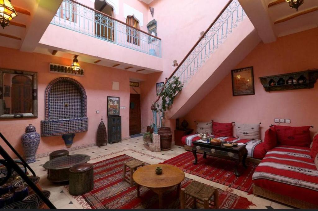 ein großes Wohnzimmer mit einem Sofa und einem Tisch in der Unterkunft RIAD SULTAN Marrakech in Marrakesch