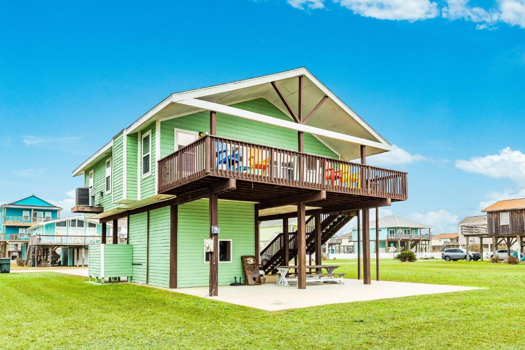 a green house with a balcony on top of it at Terramar Time in Galveston