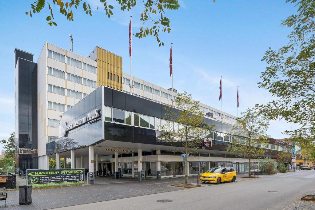 un coche amarillo estacionado frente a un edificio en Best Western Plus Airport Hotel, en Copenhague