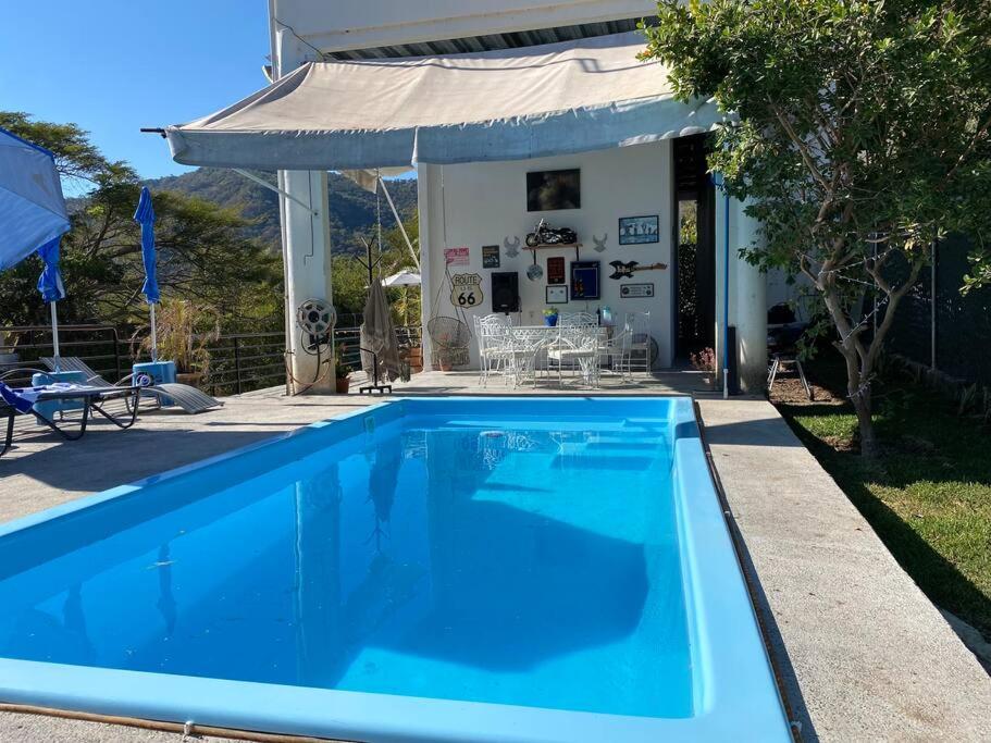 uma grande piscina azul em frente a uma casa em El Cielo en la laguna. em Santa María del Oro
