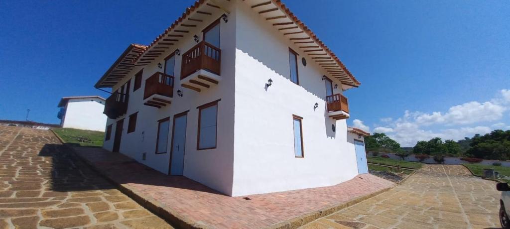 un edificio blanco con un cielo azul en el fondo en Acogedora Casa en Barichara en Barichara