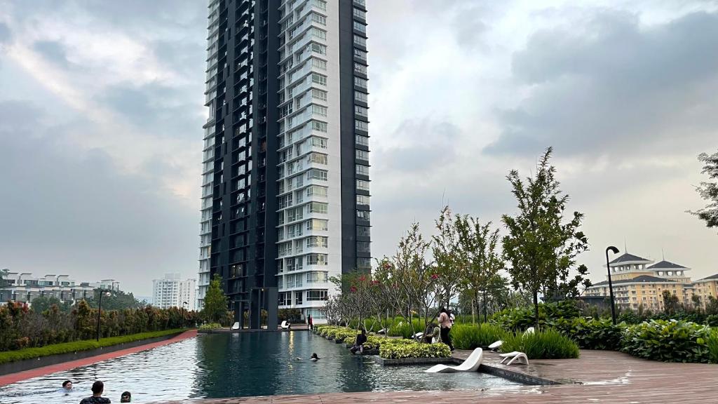 a large building with swans in the water in front of it at Hannah's Cottage at KL East The Ridge in Kuala Lumpur