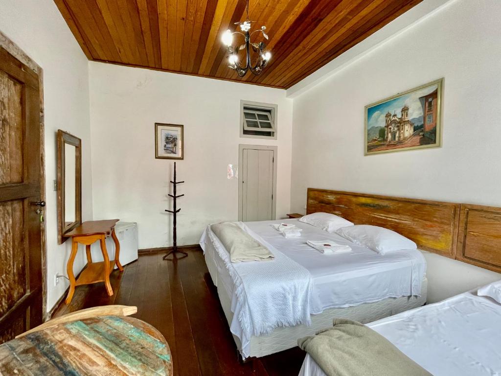 sypialnia z 2 łóżkami i drewnianym sufitem w obiekcie Caminhos da Liberdade Pousada w mieście Ouro Preto
