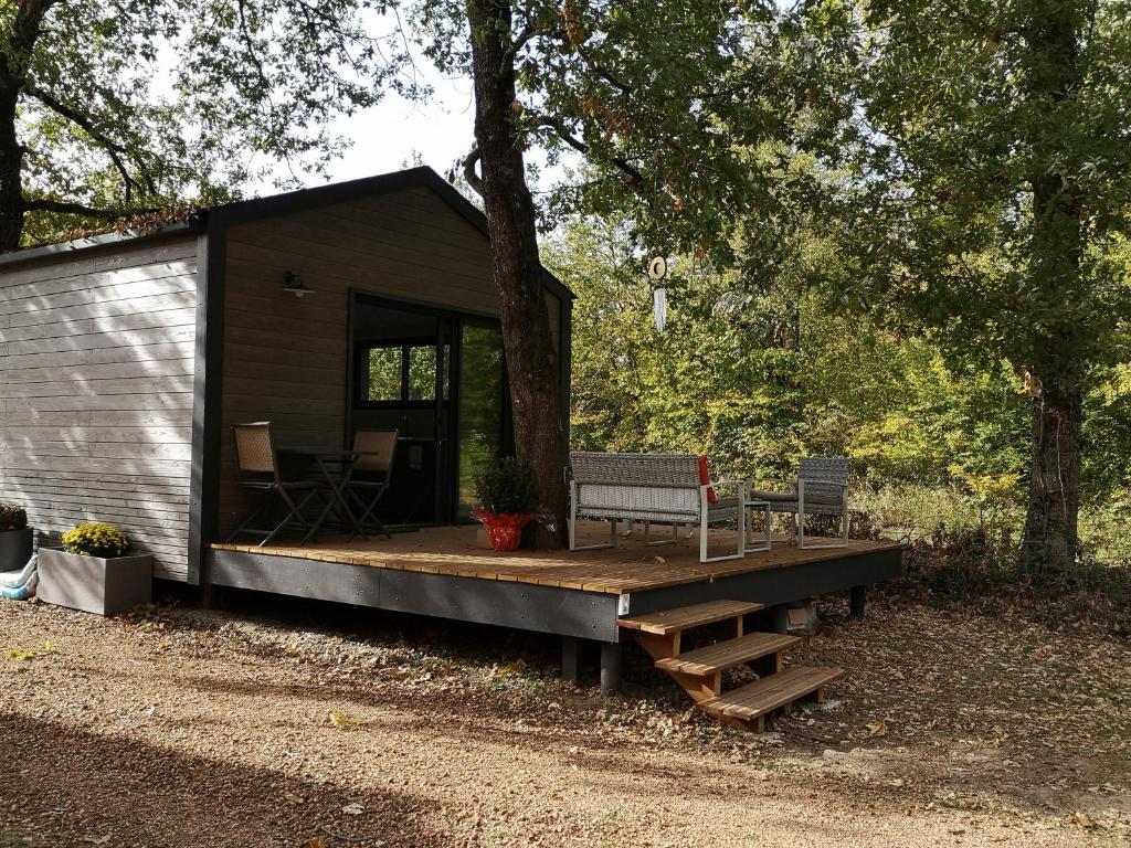 a cabin in the woods with a porch and a bench at Lodge avec terrasse in Charmeil
