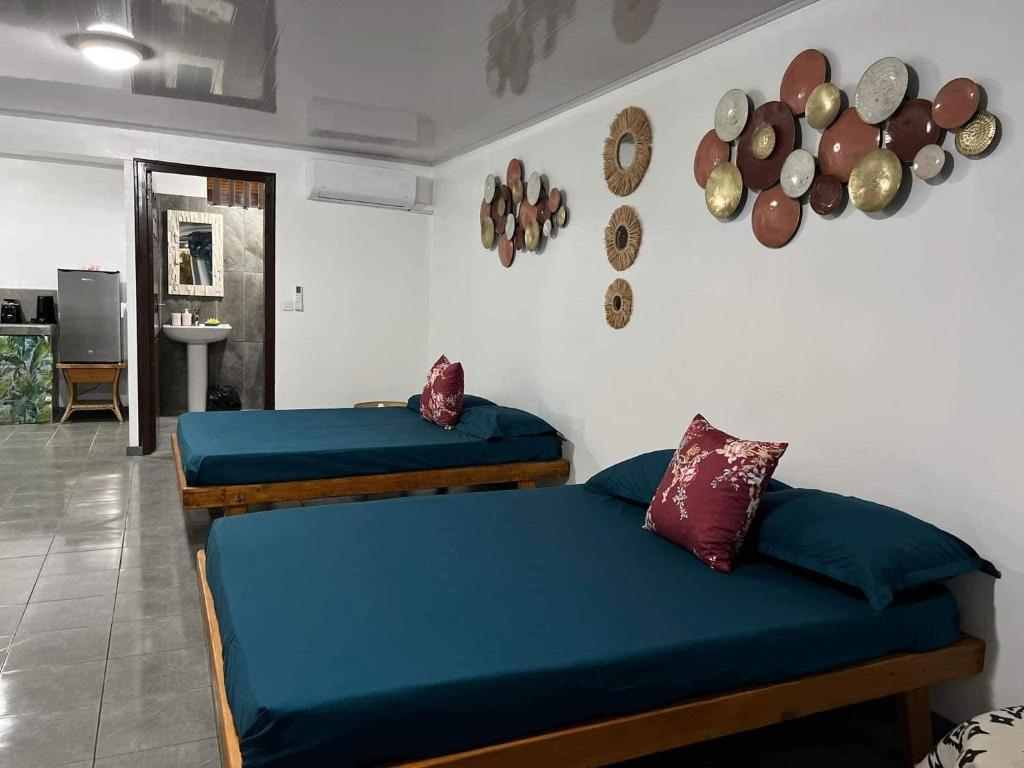 2 Betten in einem Zimmer mit blauer Bettwäsche in der Unterkunft Bora Bora Hiva Home in Bora Bora