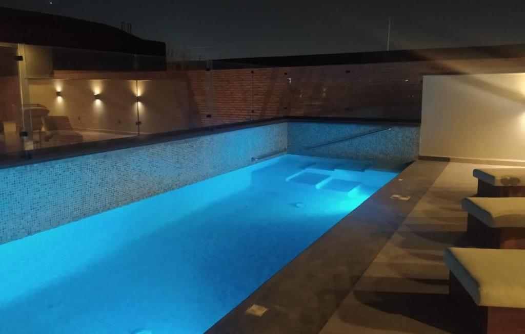 una piscina con iluminación azul en un edificio en Hotel Monarca San Luis Potosí, en San Luis Potosí