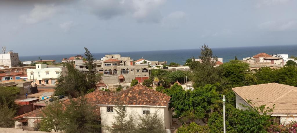 una città con case e l'oceano sullo sfondo di Résidence Marie France MENDY a Toubab Dialaw