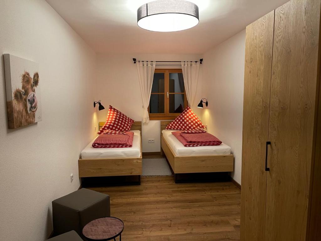 two beds in a small room with a window at Ilgerhof Ferienwohnungen in Oberaudorf