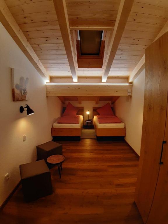 a attic room with two beds and a tv at Ilgerhof Ferienwohnungen in Oberaudorf