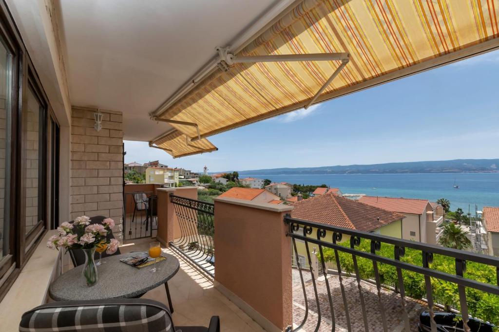 a balcony with a table and chairs and a view of the water at Room 79-2 in Duće