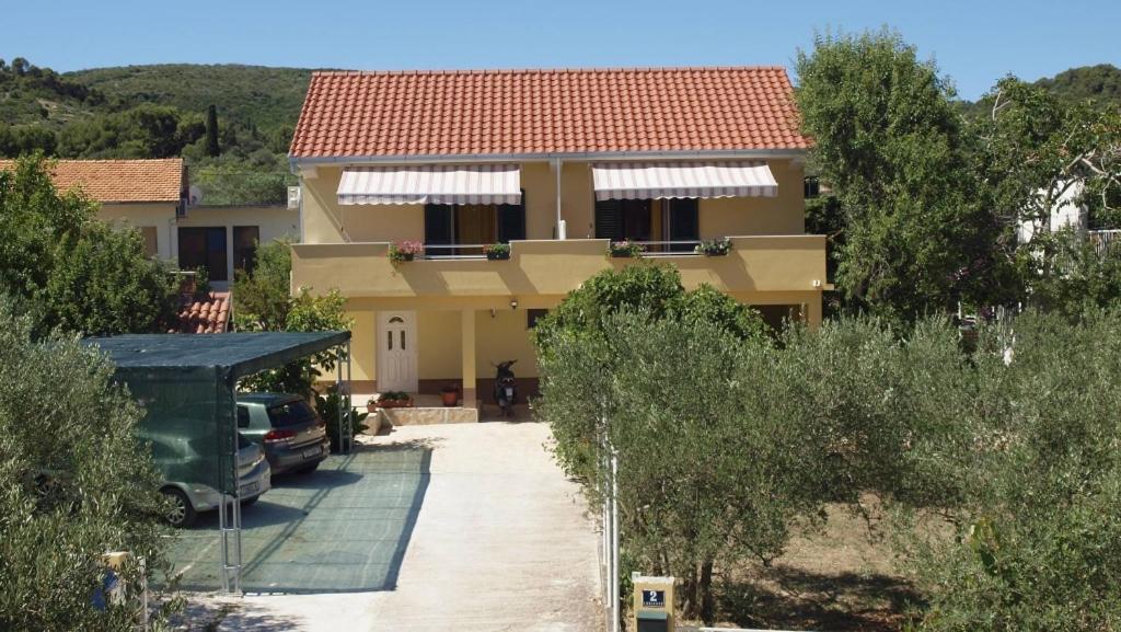 a house with a car parked in front of it at Apartment in Slatine with sea view, balcony, air conditioning, Wi-Fi (4784-2) in Slatine