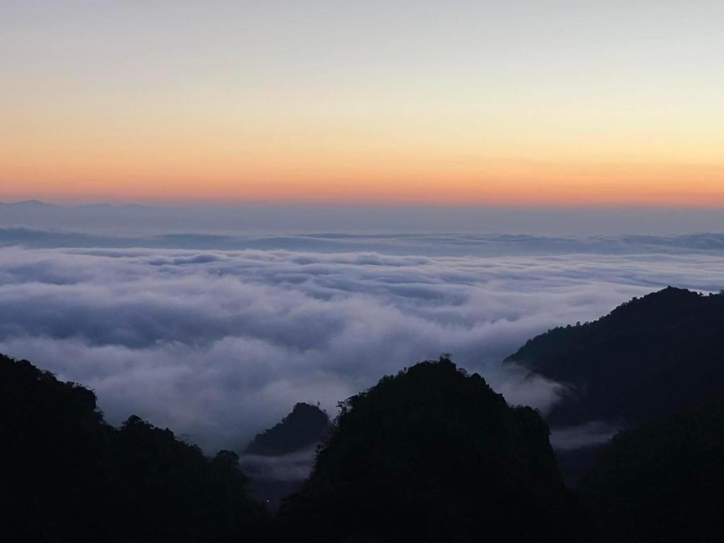 une vue depuis le sommet d'une montagne avec des nuages dans l'établissement บ้านหิ่งห้อยผาหมี Baanhinghoi phamee, à Mae Sai