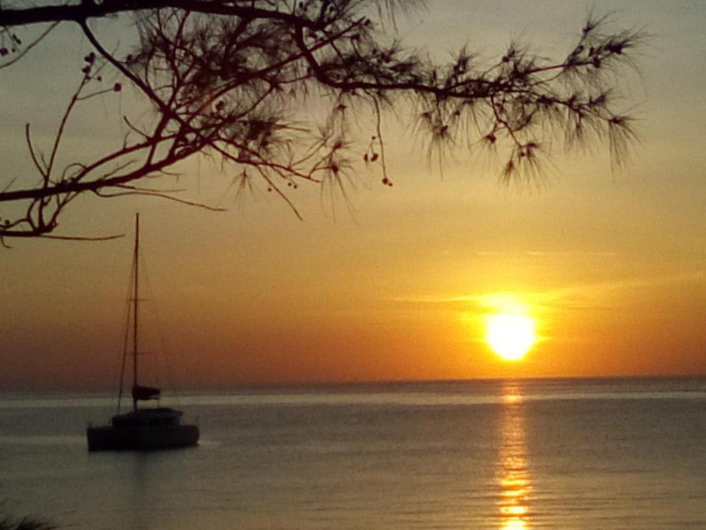 a boat sitting in the water at sunset at Ocean Breeze Villa 242 in Nassau