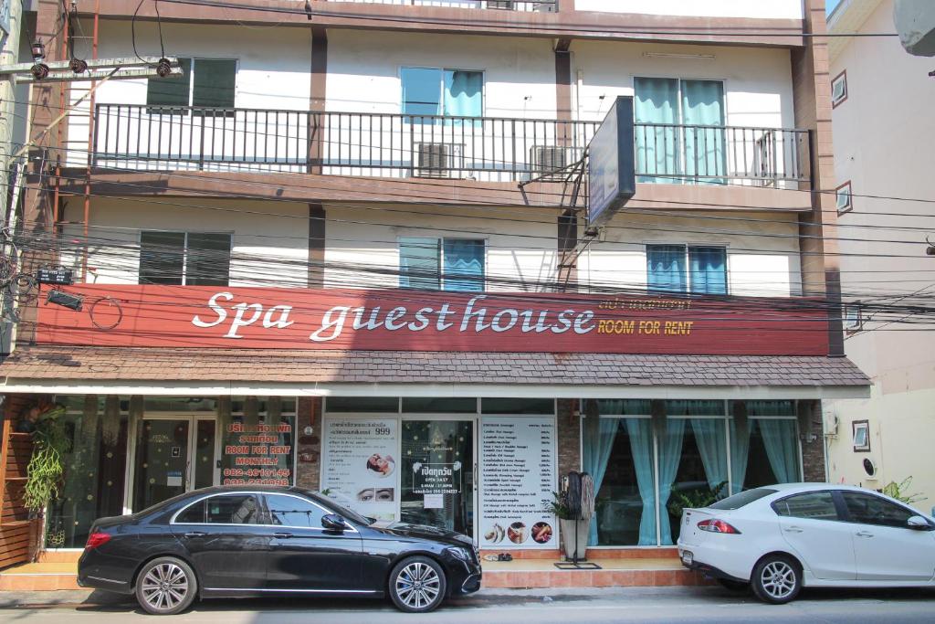 two cars parked in front of a building at Spa Guest House in Jomtien Beach