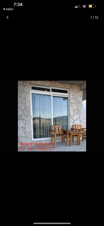 uma imagem de um pátio com dois bancos e uma janela em Chalet Castello em Ensenada