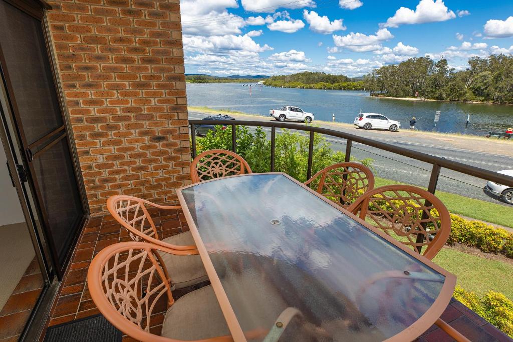 a table and chairs on a balcony with a view of a river at Braemar 3 in Forster
