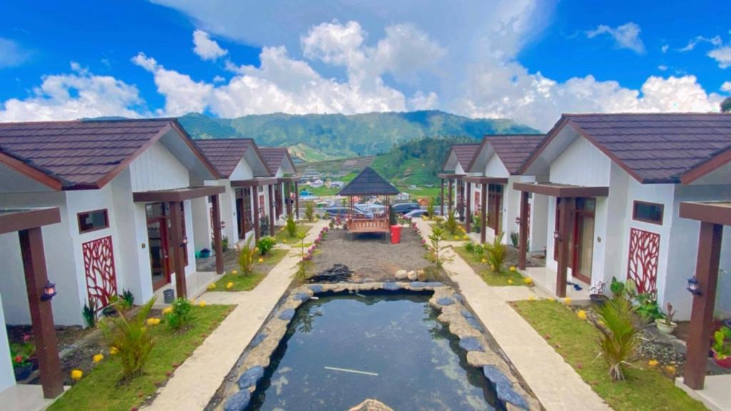 eine Reihe von Häusern mit einem Pool in der Mitte in der Unterkunft Madinna Villa Dieng in Diyeng
