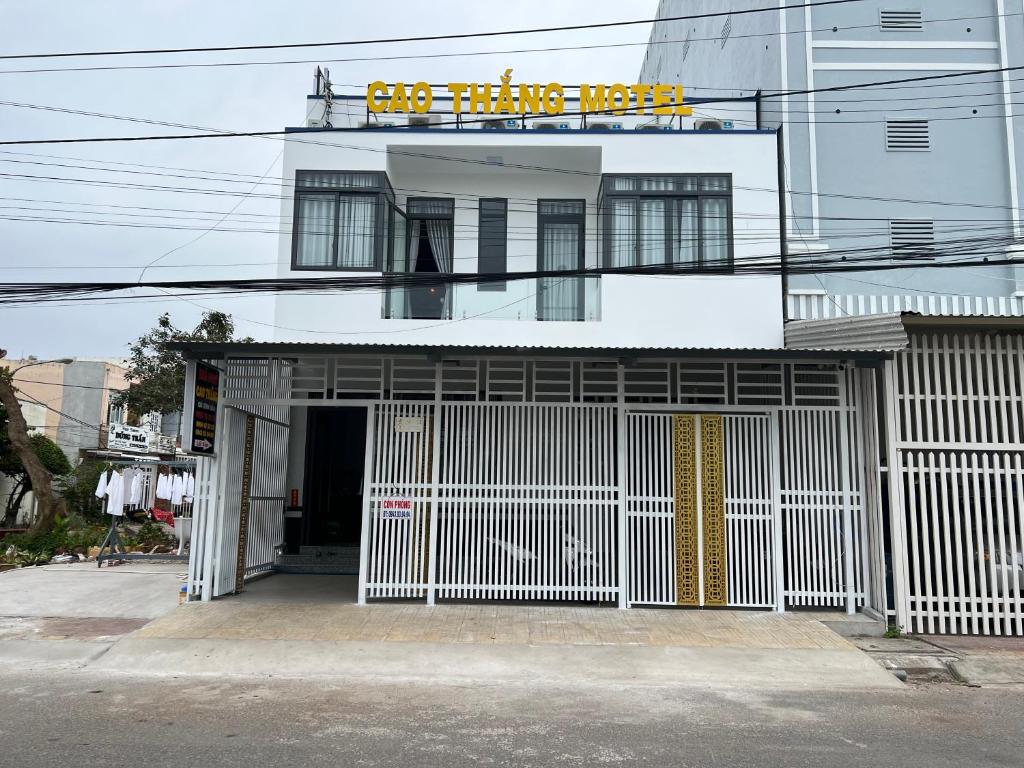 un edificio blanco con una puerta delante en Nhà Nghĩ Cao Thắng en Bạc Liêu