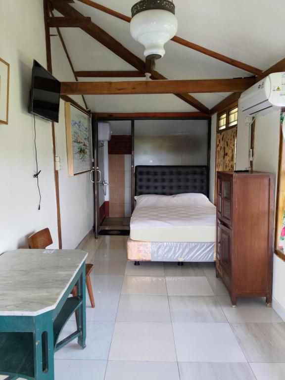 Postel nebo postele na pokoji v ubytování Omah Singo Stay & Resto Yogyakarta