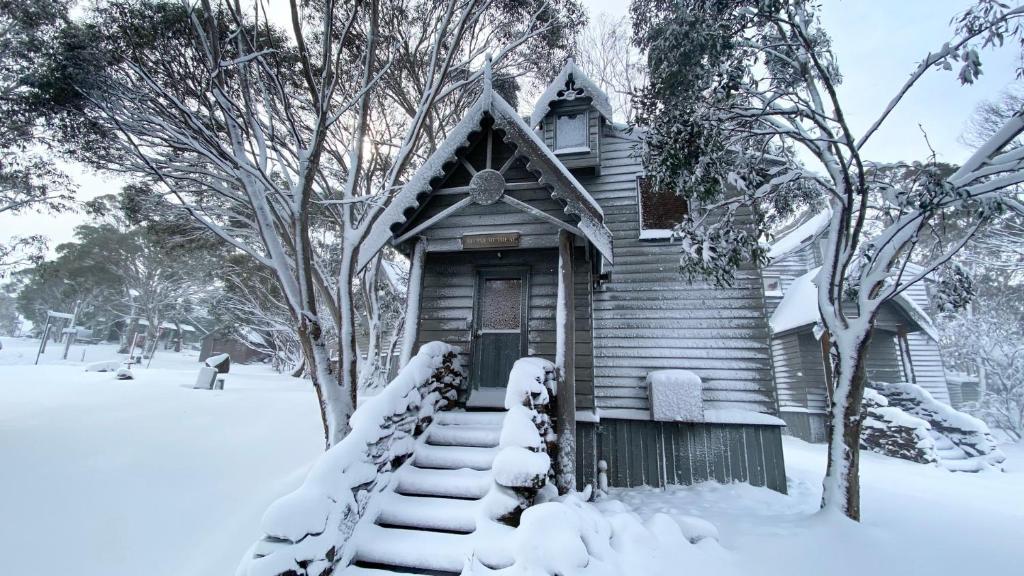 a small wooden house with snow on the steps at Alpine Retreat in Dinner Plain