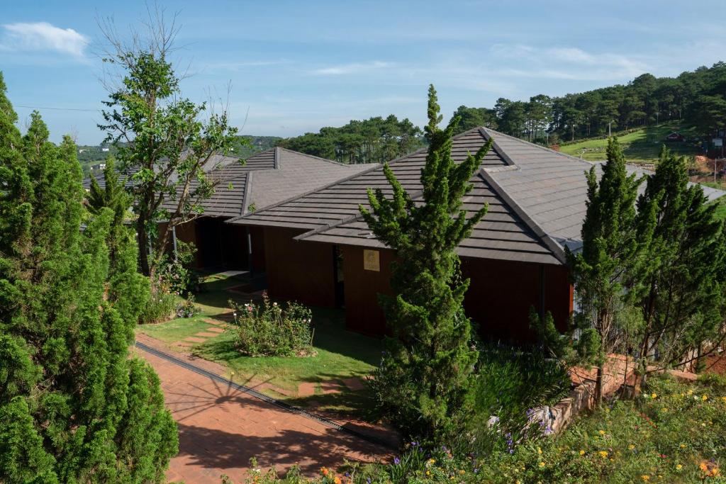 une maison au milieu d'une forêt d'arbres dans l'établissement Ngôi Làng Trong Tranh, Leading-Kiwuki Village, à Bảo Lộc