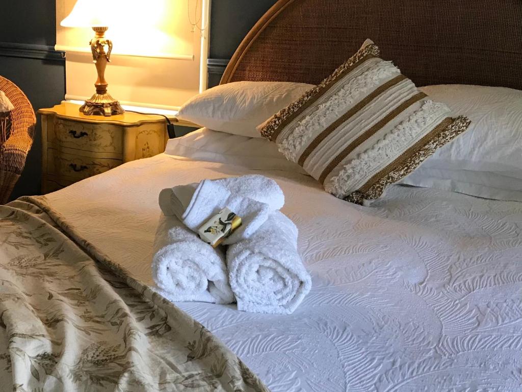 a white towel sitting on top of a bed at Hawk's Nest Bed & Breakfast in Bathurst