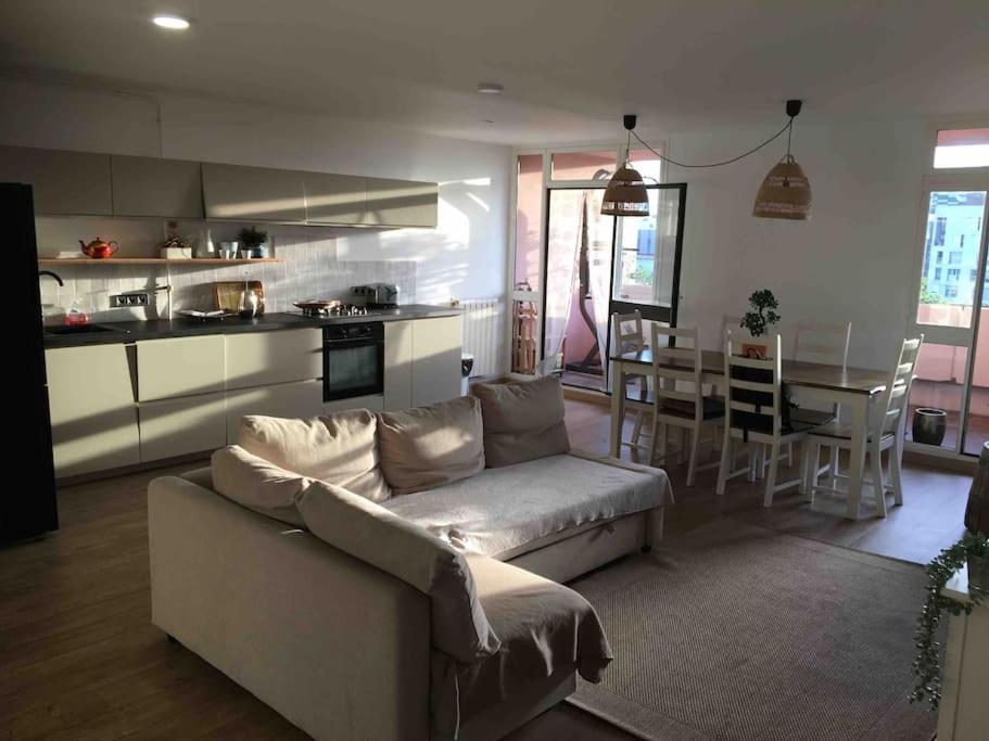 Il comprend un salon avec un canapé, une cuisine et une table. dans l'établissement FLC 3 rooms -max 10 guests - Gare St Charles 1,5km Hyper Center, à Marseille
