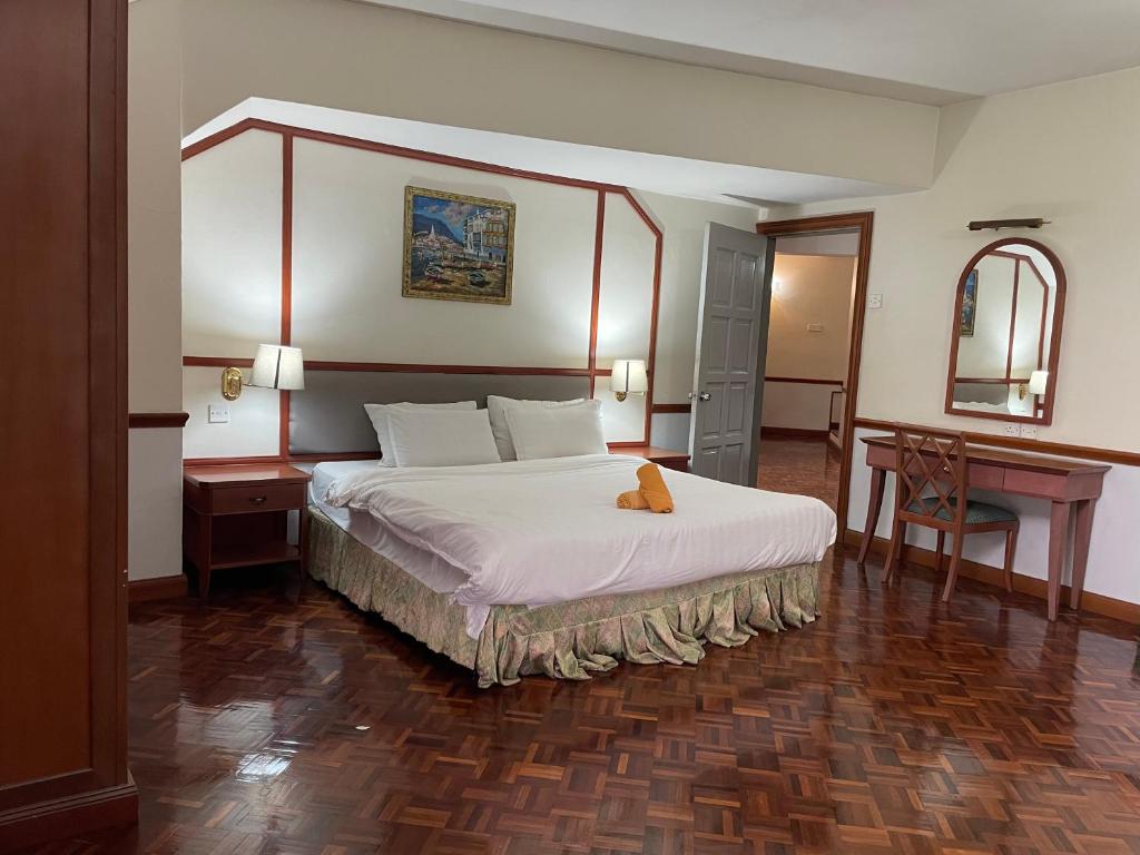 a hotel room with a large bed and a desk at Star Regency Hotel & Apartments in Brinchang