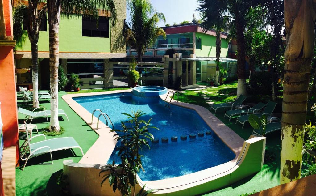 una piscina en un patio con sillas y un edificio en Hotel Cuellar en Tula de Allende