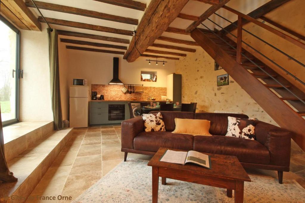 a living room with a brown couch and a table at Marguerite in Colombiers