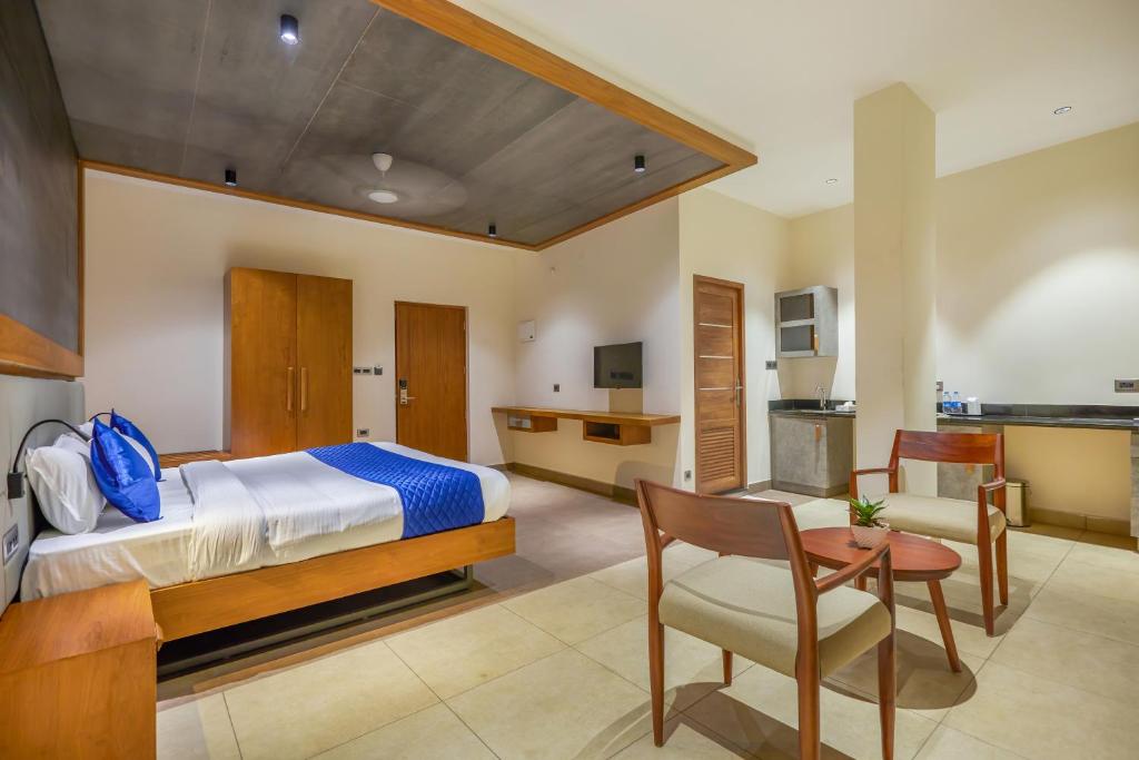 a bedroom with a bed and a table and a kitchen at HOTEL CASON INTERNATIONAL in Kondotti