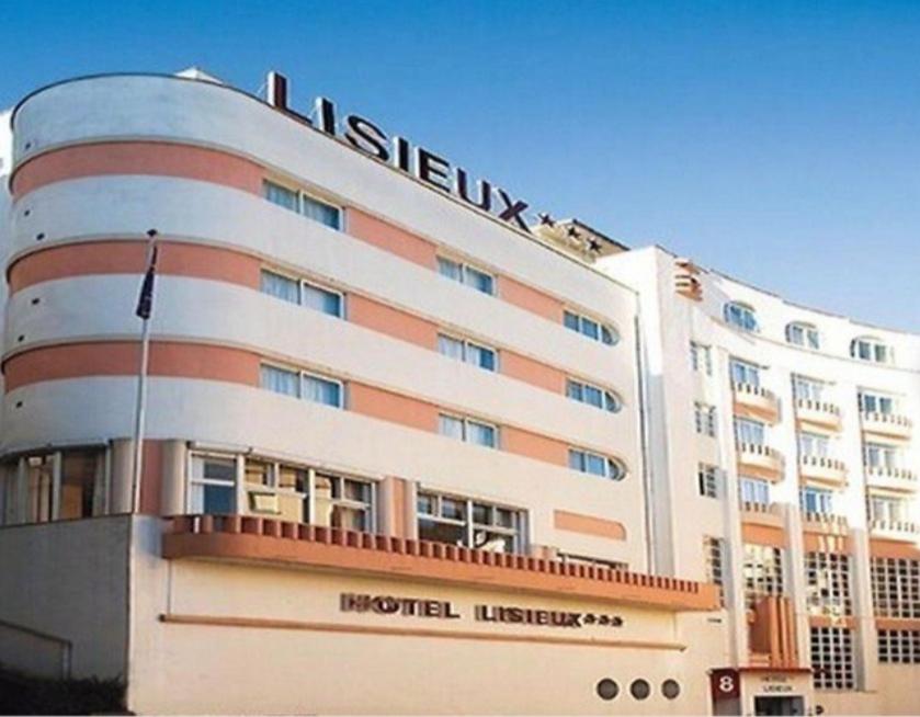 un bâtiment d'hôtel avec un panneau en haut dans l'établissement HOTEL DE LISIEUX, à Lourdes
