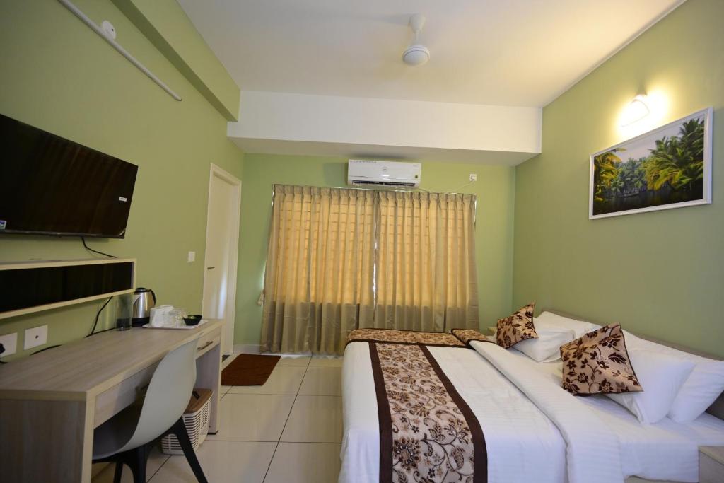 una habitación de hotel con una cama y un escritorio en RG's The 4th Residency, en Trivandrum
