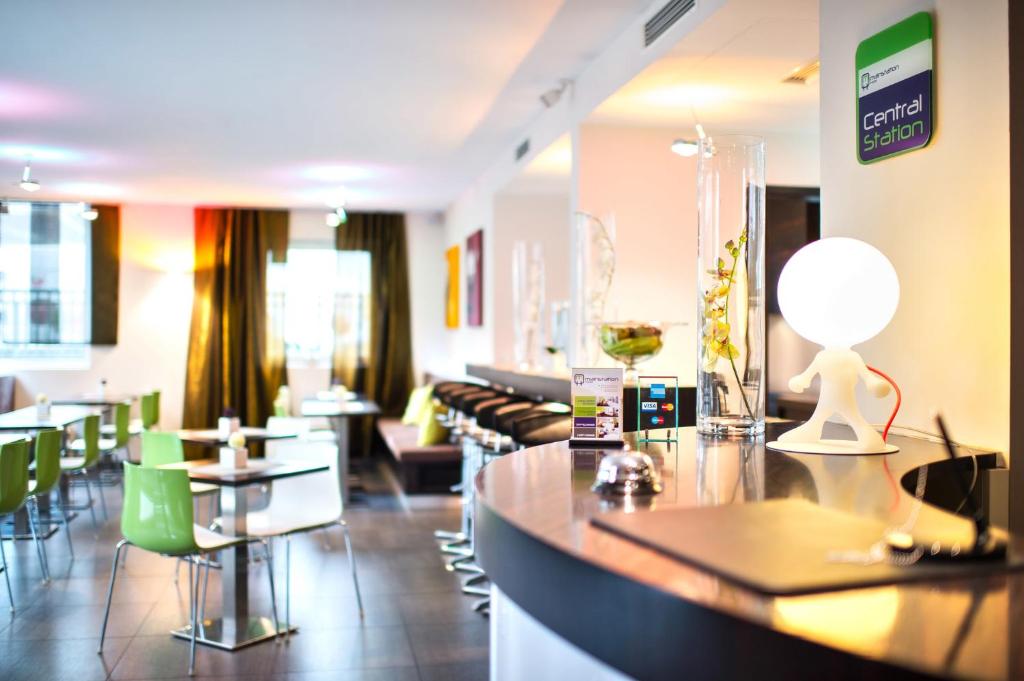 un restaurant avec un bar doté de tables et de chaises dans l'établissement Hotel Mainstation, à Francfort-sur-le-Main