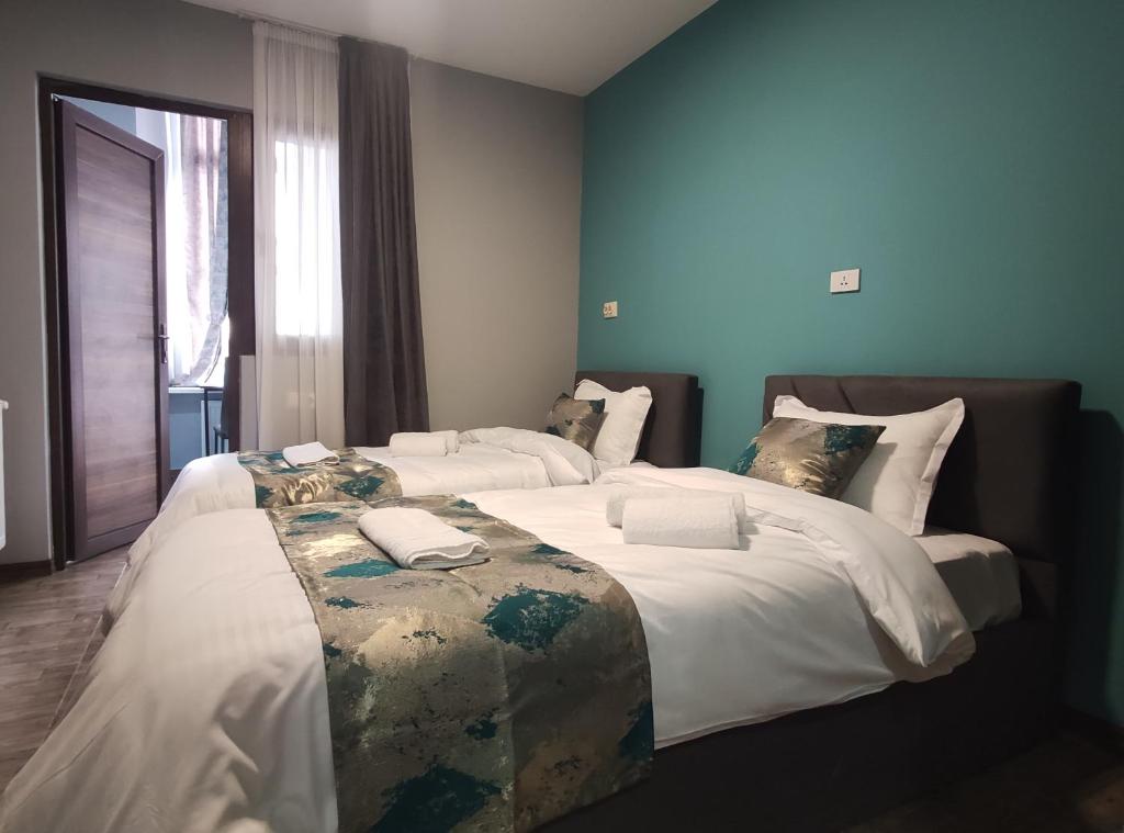 - 2 lits dans une chambre aux murs bleus dans l'établissement tbilicity hotel, à Tbilissi