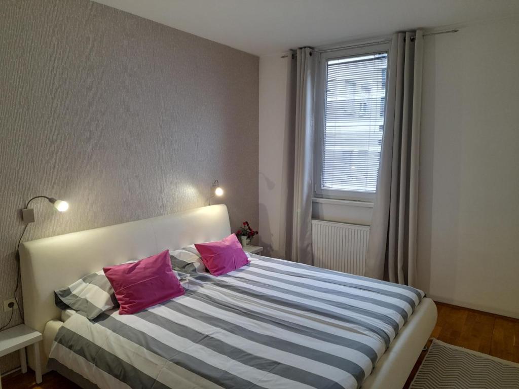 a bedroom with a bed with two pink pillows at ARS VIP Apartment in Novi Sad