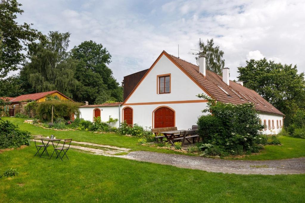 ein weißes Haus mit einem Picknicktisch im Hof in der Unterkunft Chalupa v Meziluzi in Meziluží