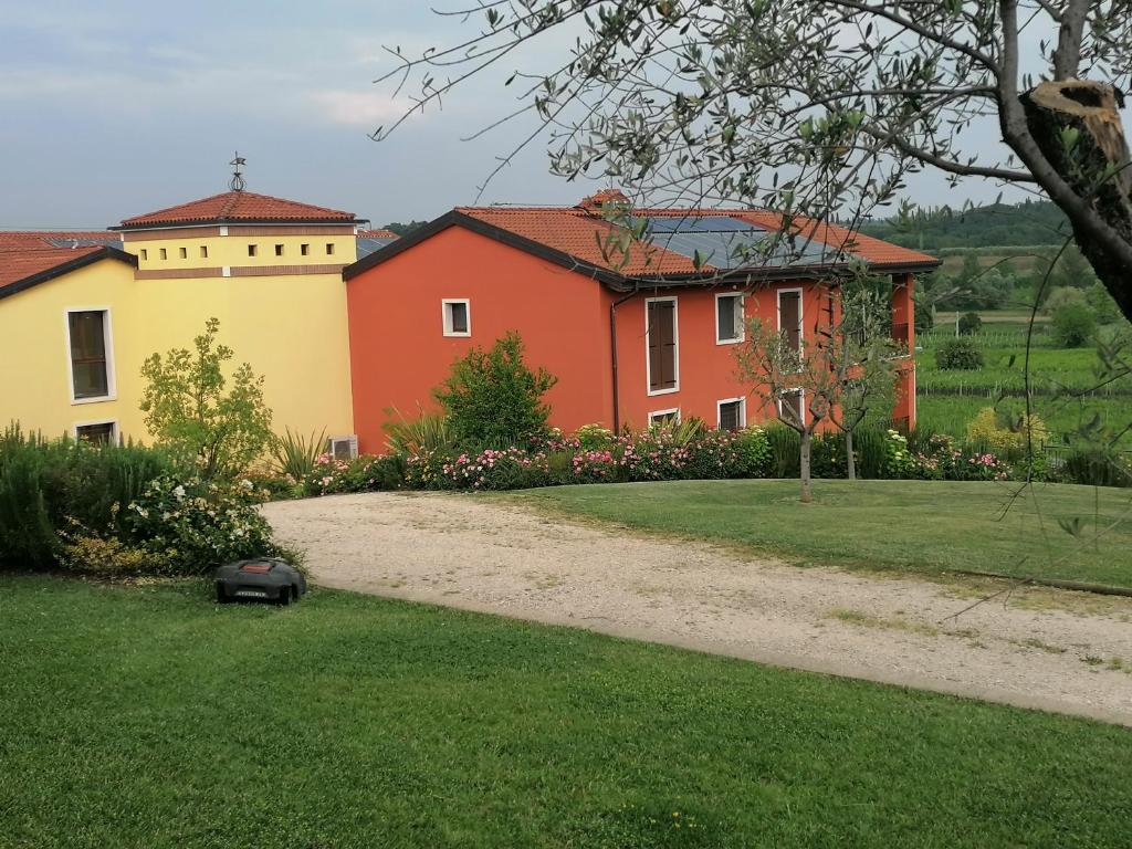 a house and a driveway with a grass yard at Agriturismo La Rondinella in Lazise