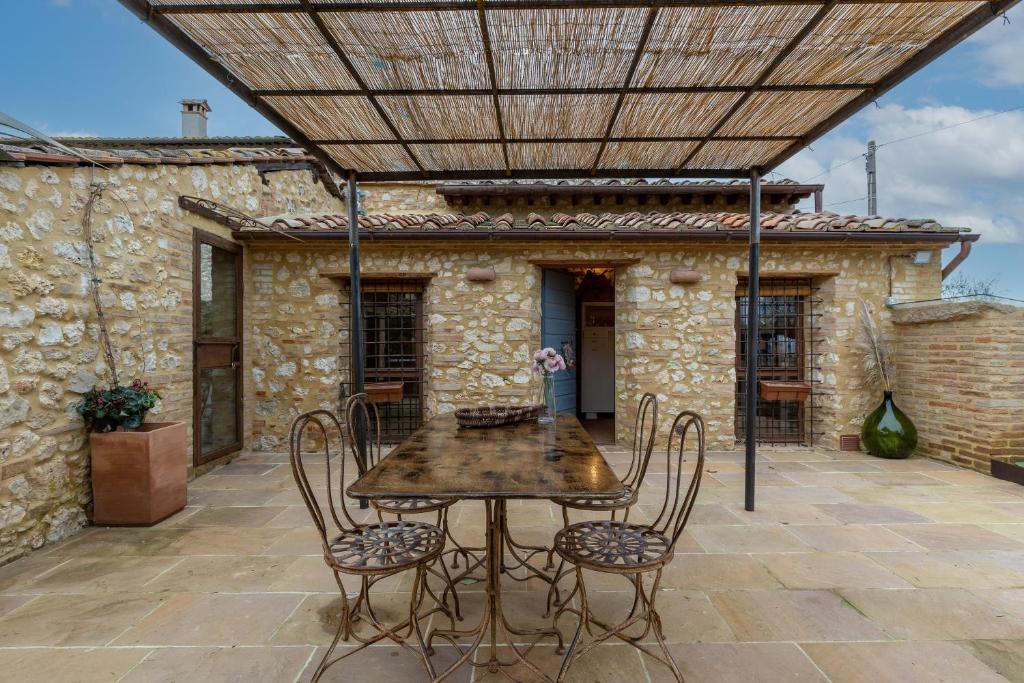a patio with a table and chairs under a roof at Casa di Campagna in Colle Val D'Elsa