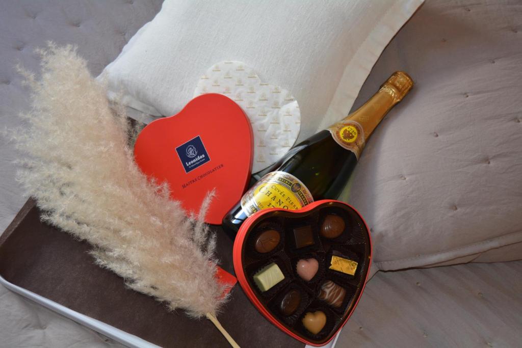 a bottle of champagne next to a heart and a thermometer at Hôtel Ulysse Montpellier Centre in Montpellier