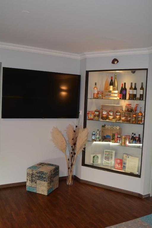 a room with a refrigerator with a shelf with bottles at Hôtel Ulysse Montpellier Centre in Montpellier
