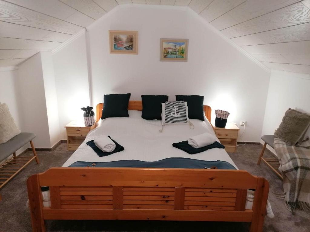 Un dormitorio con una cama grande con almohadas. en Gemenc Vendégház Baja, en Baja