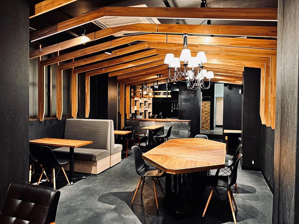 un restaurante con mesas y sillas y un bar en Namba Guesthouse HIVE, en Osaka