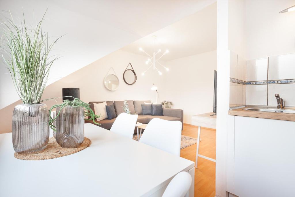 una sala de estar blanca con mesa blanca y sillas en CenterApartment, WIFI, SmartTV, full Kitchen, Netflix, Pottbude in Essen en Essen