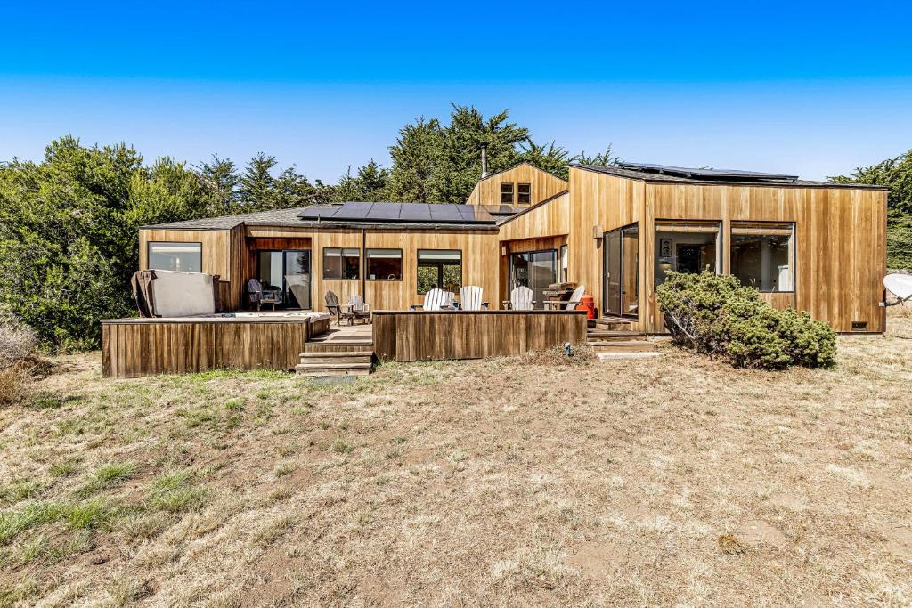 une grande maison en bois dans un champ dans l'établissement Urban Escape, à Sea Ranch