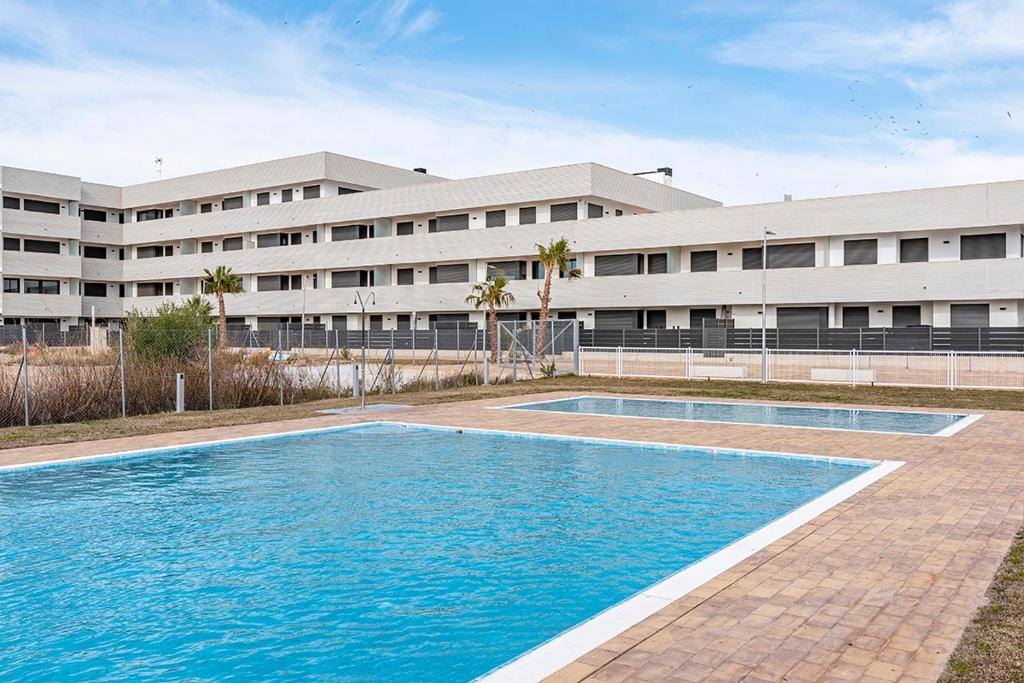 a swimming pool in front of a building at Apartamento La cala in L'Ametlla de Mar